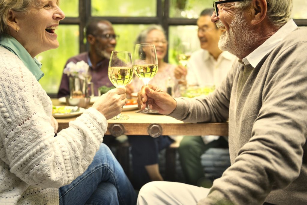 Group of happy retired seniors meet up in a restaurant